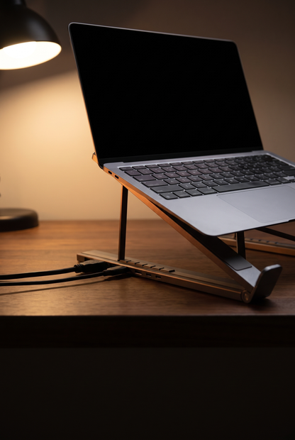 Support avec hub intégré le soir sur un bureau en noyer, câbles branchés sur la base