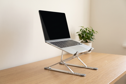 Ordinateur portable relevé sur le support pliable en aluminium, sur un bureau en chêne